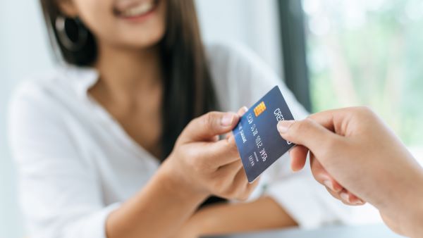 photo of woman handing her credit card for processing
