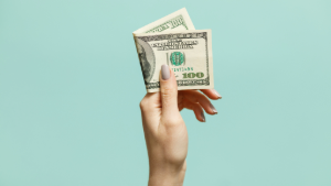 Picture of hand holding a 100 dollar bill